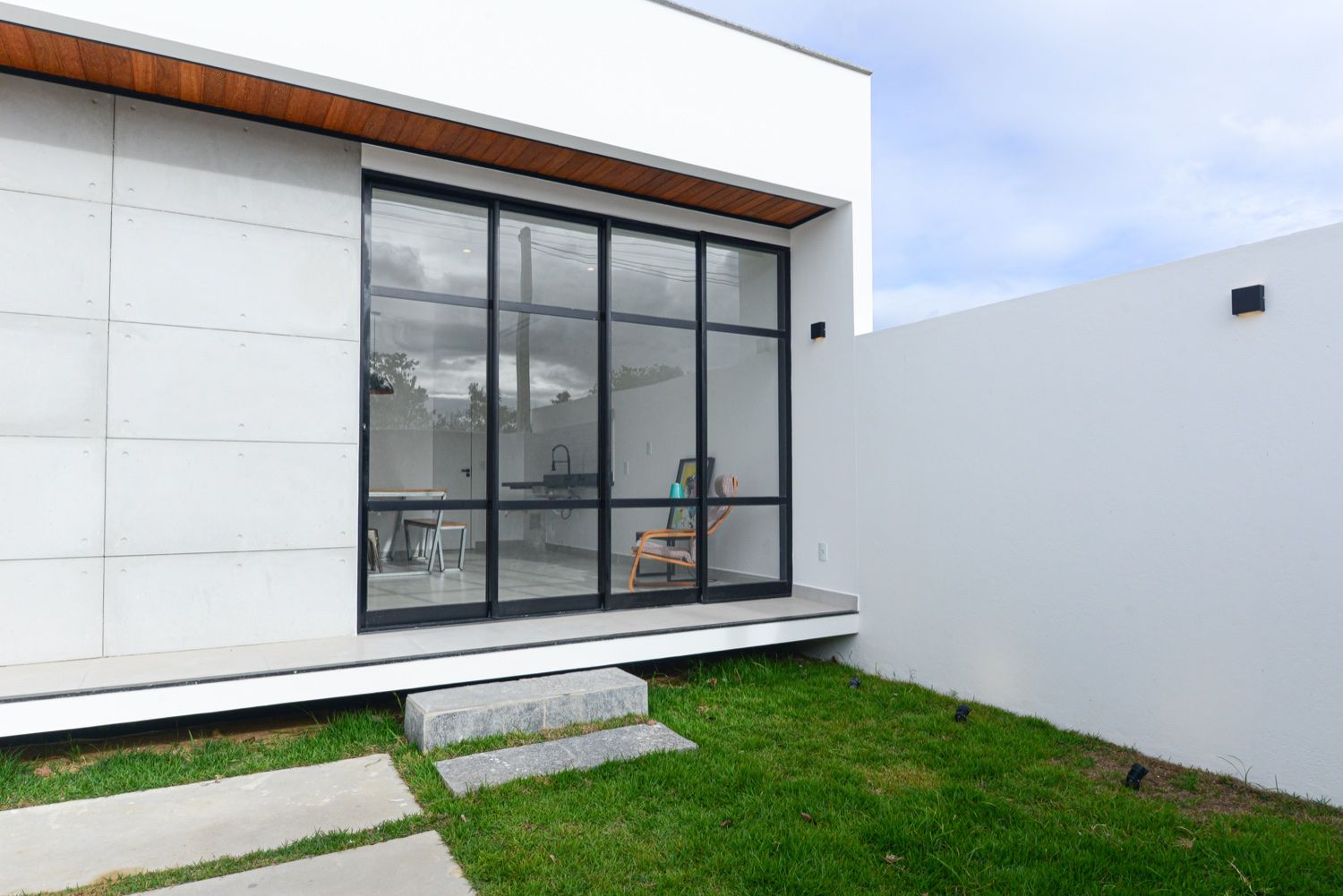 Casa Cubo3 — fachada dos fundos com jardim, cobogó e esquadrias pretas